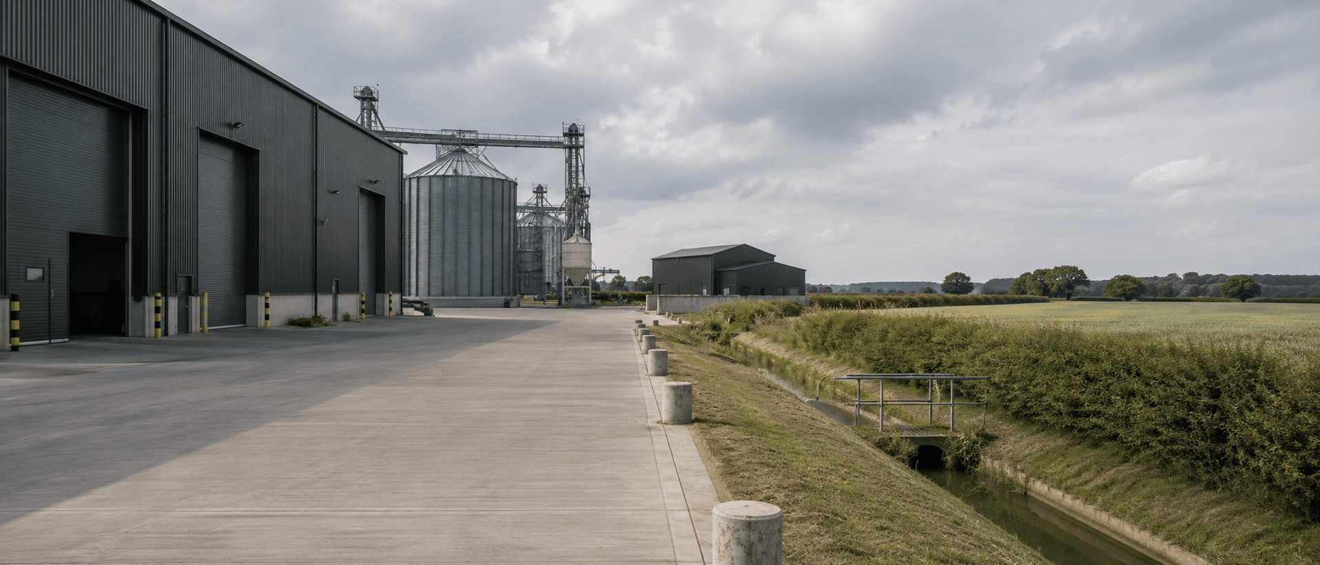 A Stratton-managed agricultural site with grain stores and farm buildings beside open land.