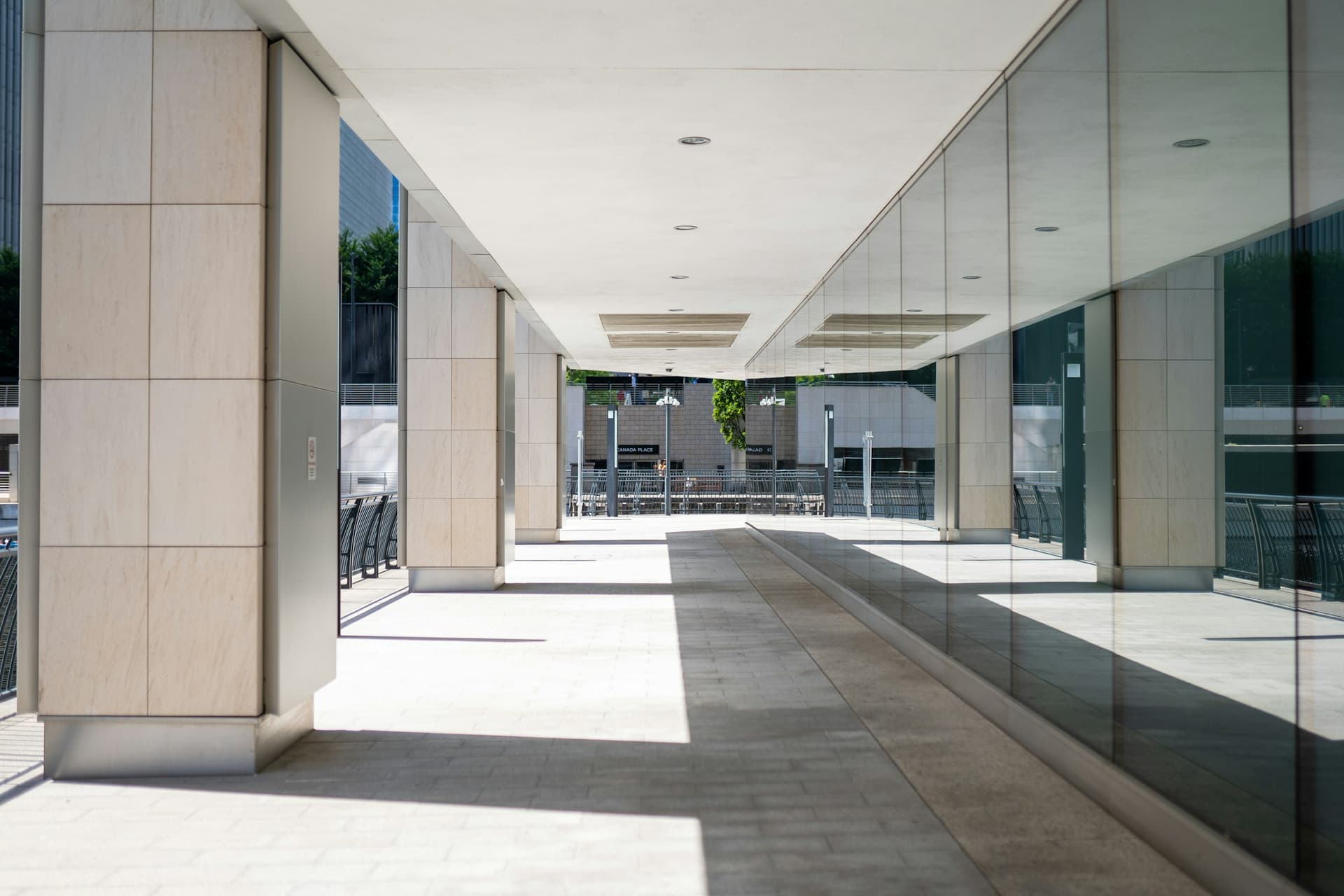 A colonnade at Canary Wharf, London: stone columns and glass in a long, even rhythm.